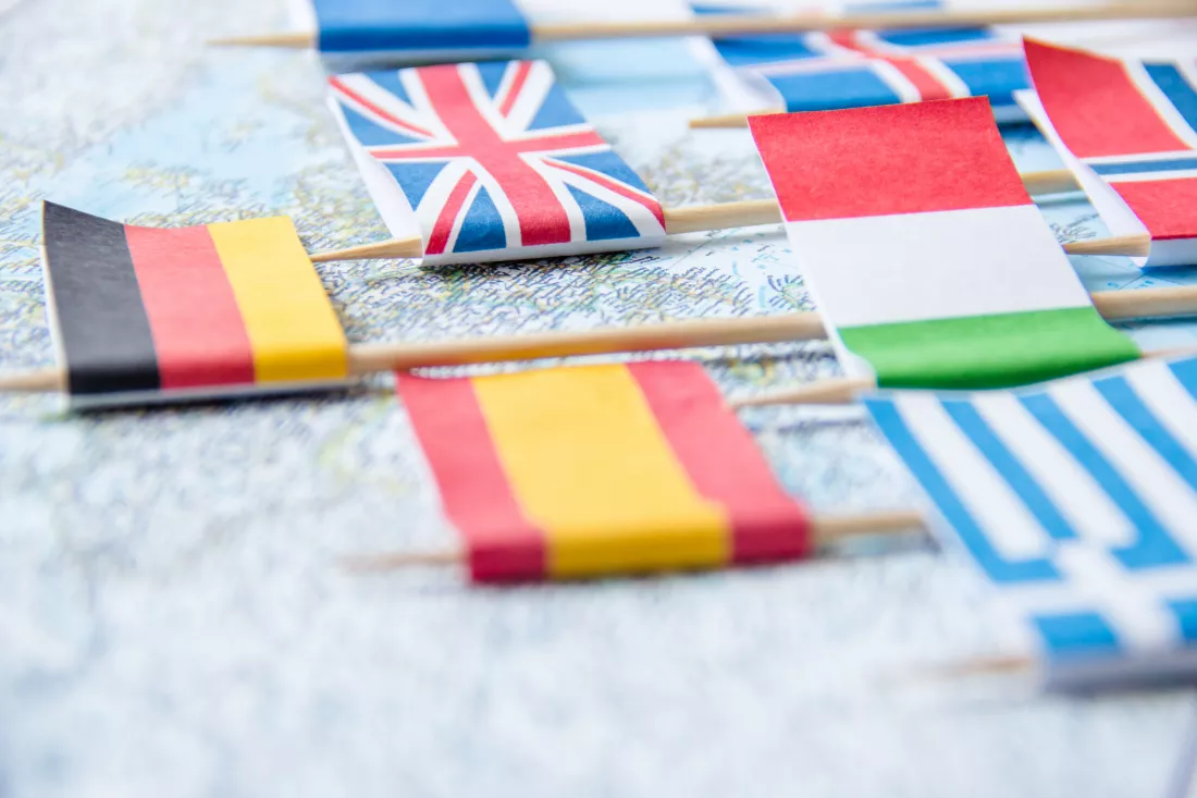 road-map-national-flags-close-up-wooden-table